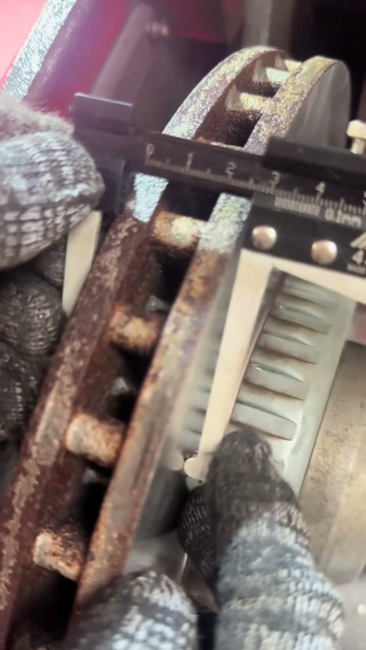 Measuring a worn brake rotor with a caliper before machining